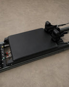 Carro negro de Reformer de Pilates con hombreras ajustables