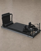Reformer de Pilates telescópico negro con estructura de aluminio